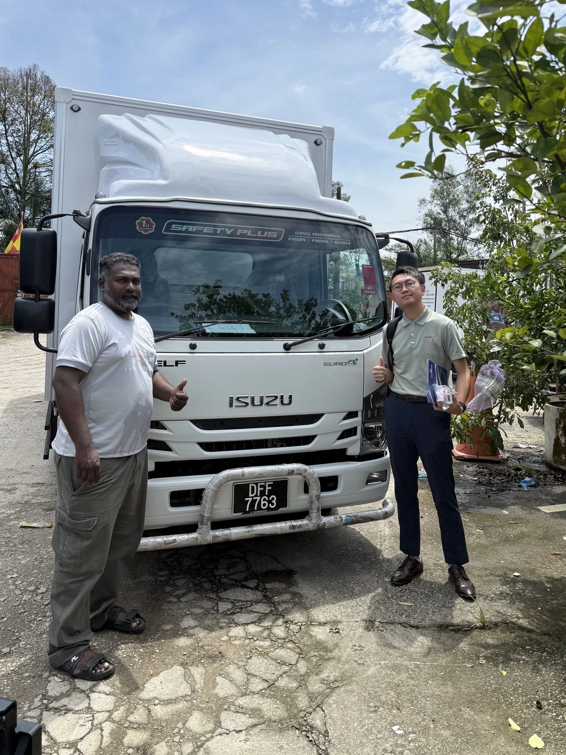 Adam with a customer beside a delivered Isuzu lorry